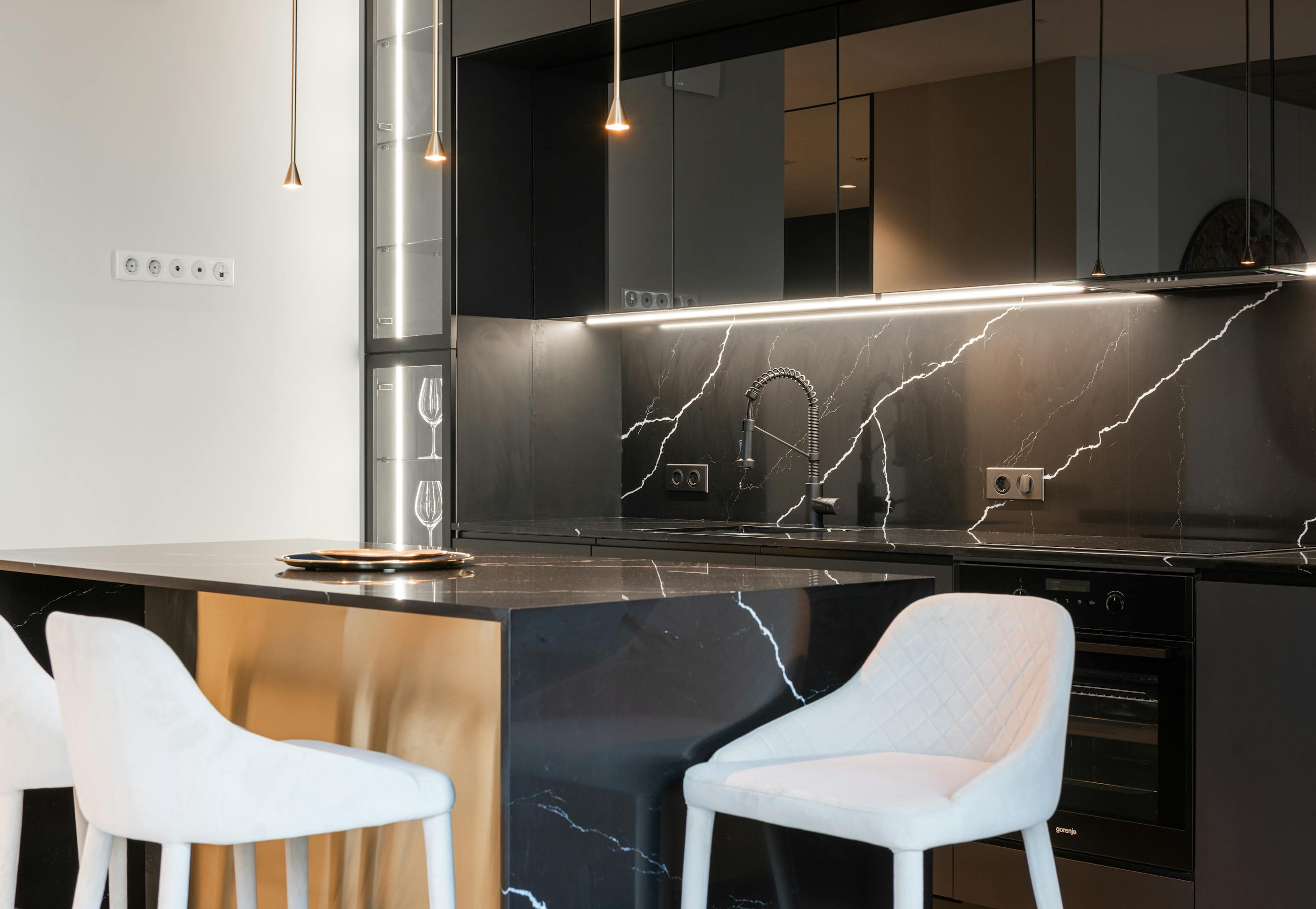 Custom luxury kitchen with marble waterfall island, brass hardware, and integrated cabinetry